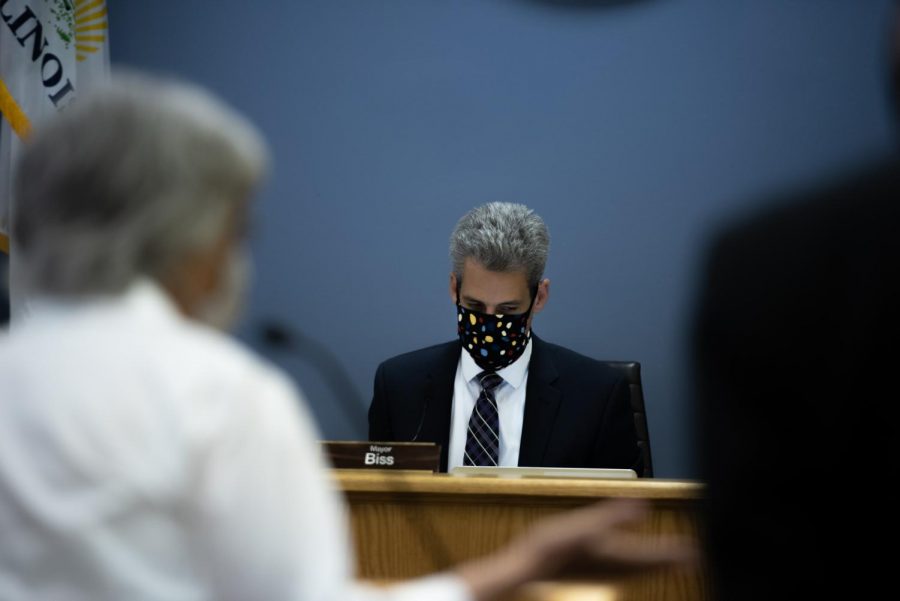 Mayor Daniel Biss looks down while sitting at his desk.