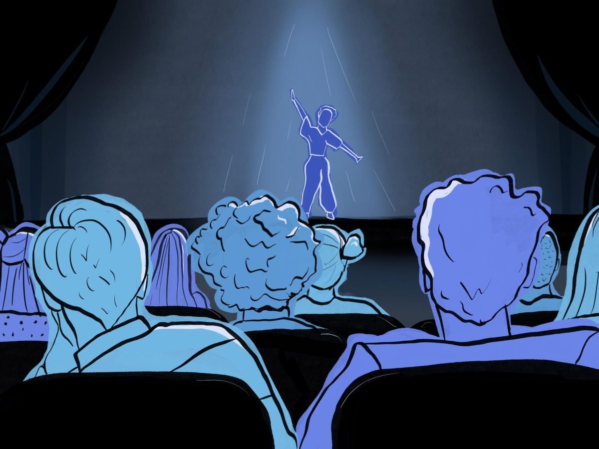 People watch a performer on a stage.